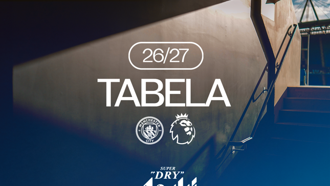Graphic showing '26/27 TABELA' with Manchester City and Premier League logos, and an Asahi Super Dry logo. Background features a stadium entrance tunnel.