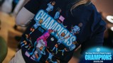 A close-up of a shirt featuring cartoon football players celebrating. It reads 'WSL Champions 25/26' and 'Barclays Women's Super League Champions 2025/26'.