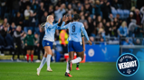 Two Manchester City women players celebrating during a football match, wearing light blue jerseys, with a crowd in the background.