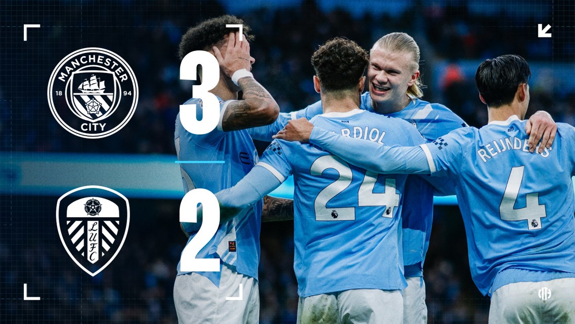 Manchester City defeated Leeds United with a 3-2 scoreline. The image shows Manchester City players celebrating the victory. The Manchester City and Leeds United logos are displayed, along with the final score.