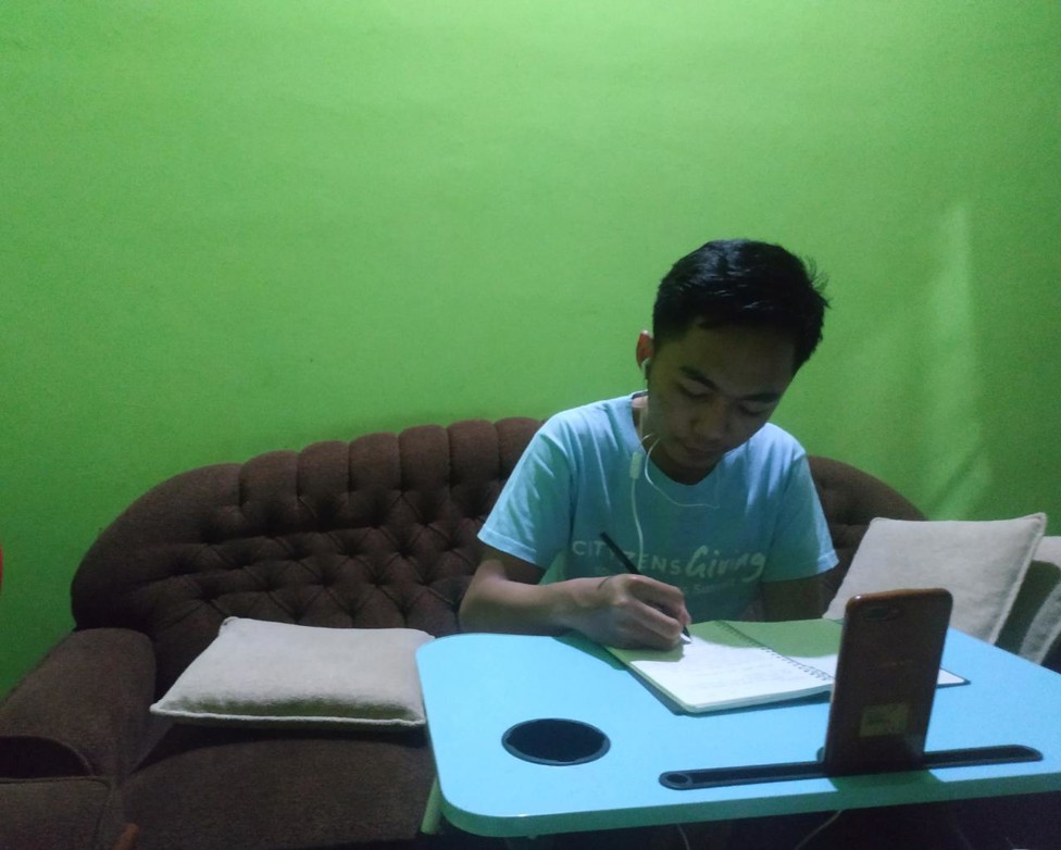 Gilang mencatat poin-poin penting dari materi yang disampaikan