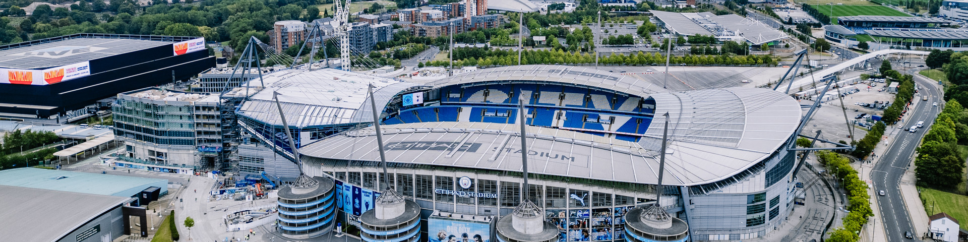 Aerial view of Etihad Stadium, home of Manchester City Football Club, showing surrounding areas and ongoing construction.