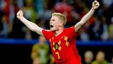 A football player in a red Belgium national team jersey with number 7 is celebrating with raised arms during a match.