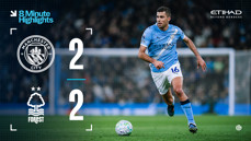 Scoreboard showing Manchester City 2-2 Nottingham Forest with blurred player in action on the field.