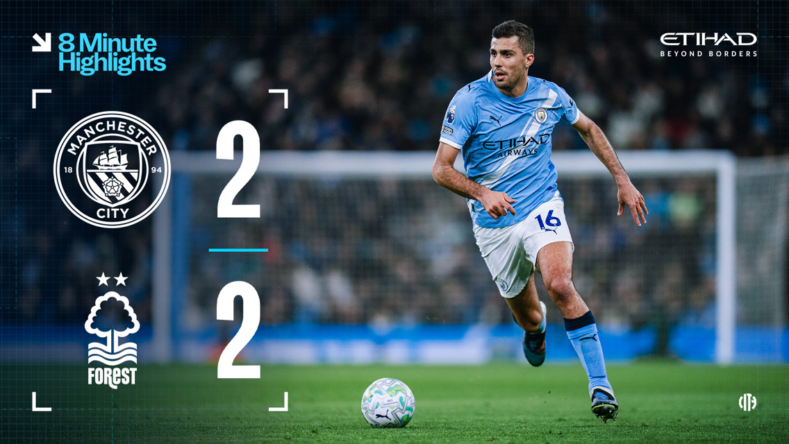 Scoreboard showing Manchester City 2-2 Nottingham Forest with blurred player in action on the field.