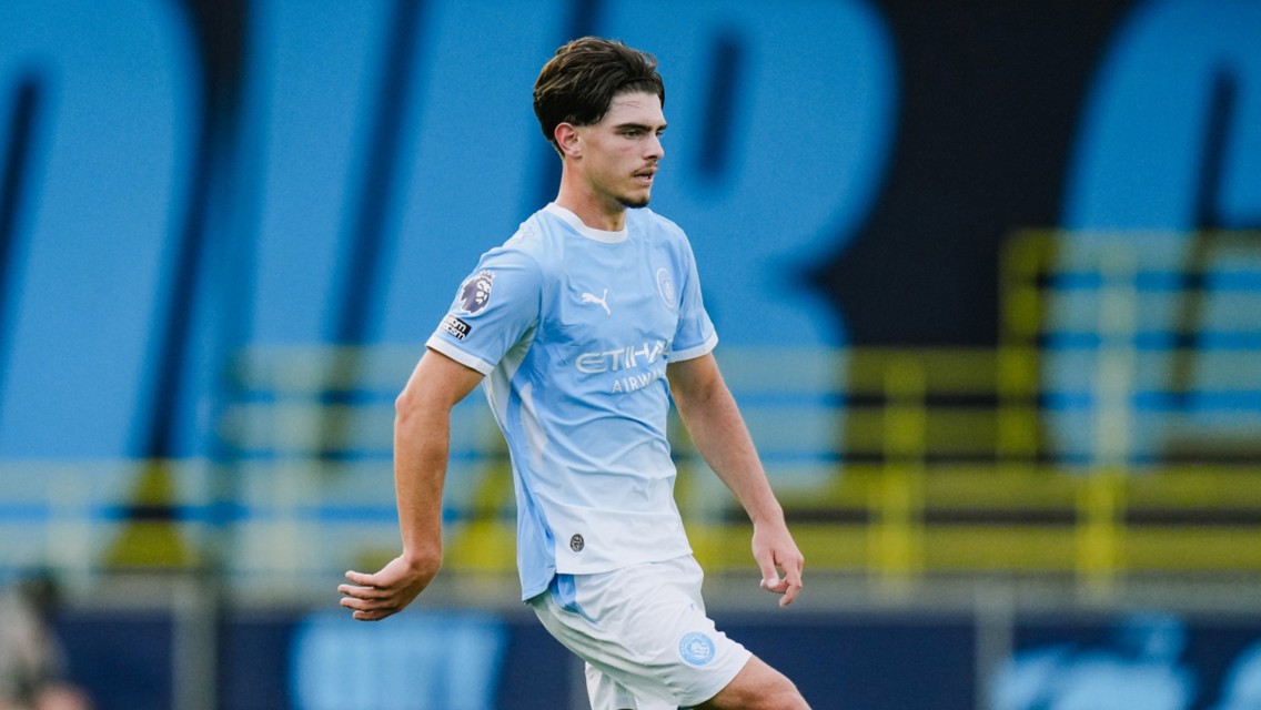 A football player in a Manchester City kit, on the field during a match.