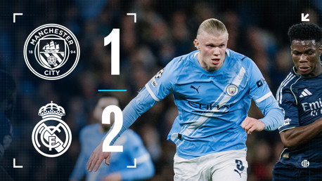 Scoreboard image of Manchester City vs Real Madrid match with score 1-2. A player in Manchester City's uniform is in action with another player.