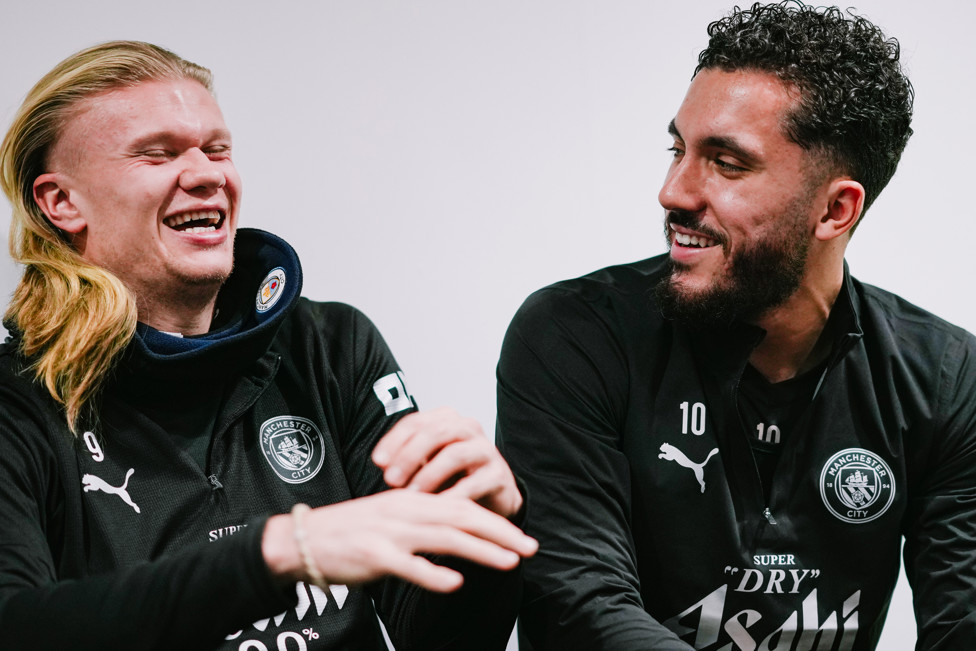 WHAT'S SO FUNNY? : Erling Haaland and Rayan Cherki share a joke. 