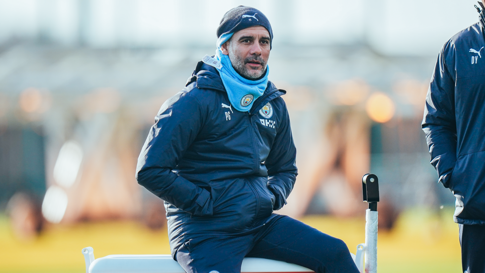 THE BOSS : Pep Guardiola takes a seat while watching his players go to work