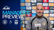 A man in a Manchester City jacket sits at a press conference. Text reads 'Manager's Preview' next to logos for Manchester City and Coventry City. The backdrop displays various sponsor logos.