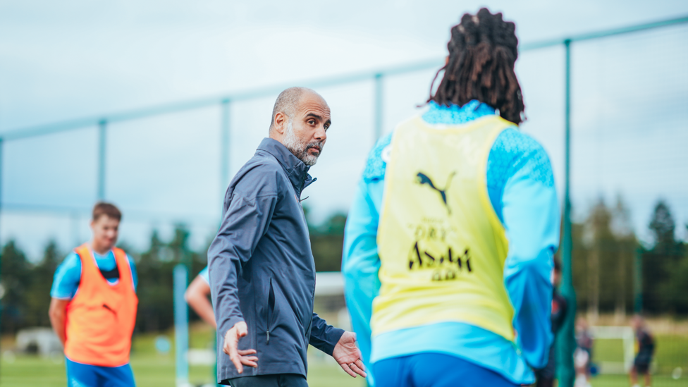 OUR LEADER : Pep Guardiola offering words of wisdom to Nathan Ake during training. 