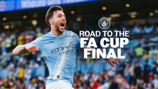 A Manchester City football player in a light blue jersey is celebrating on a football pitch. The background has blurred spectators. Text on the image reads 'Road to the FA Cup Final' with the Manchester City logo.