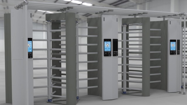 A row of full-height turnstiles with electronic access control systems and screens.