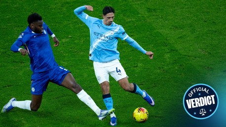 Football players in Chelsea and Manchester City kits contesting a ball on the pitch, with 'Official Verdict' graphic.