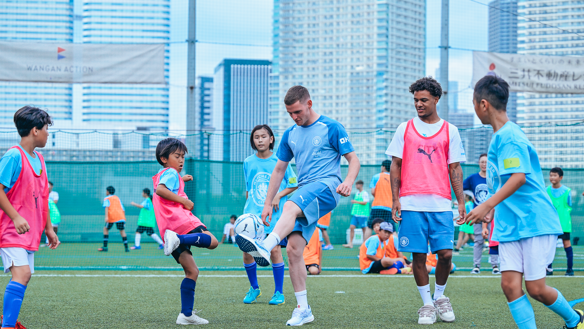 ACTION STATIONS: Sergio Gomez and Oscar Bobb play alongside some excited youngsters.