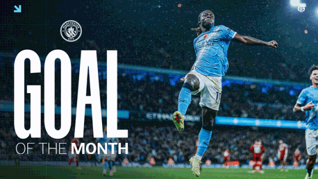 A Manchester City player in a light blue jersey celebrating a goal in an image marking 'Goal of the Month' at Etihad Stadium.