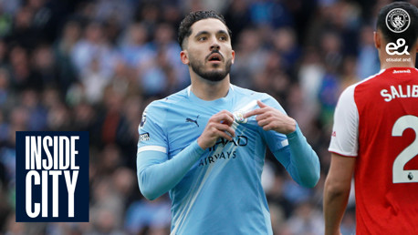 A Manchester City player in a light blue kit adjusts his shirt with a blurred face. Arsenal player in a red and white kit visible. Text reads 'INSIDE CITY'.