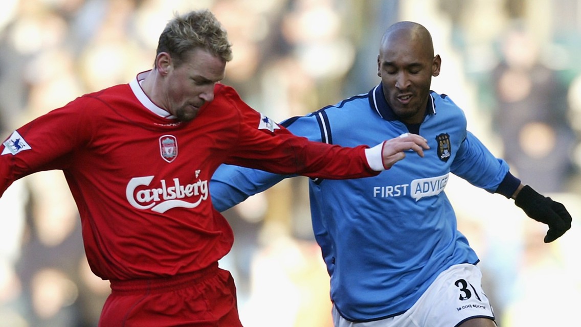 Two football players competing during a match between Liverpool and Manchester City.