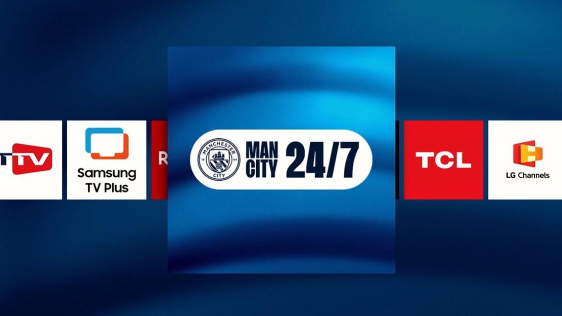 A logo of 'Man City 24/7' channel centered on a blue background with service logos like Samsung TV Plus on either side.