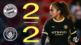 Image featuring a Bayern Munich vs Manchester City match score of 2-2, with a Manchester City player in the foreground wearing a black kit.