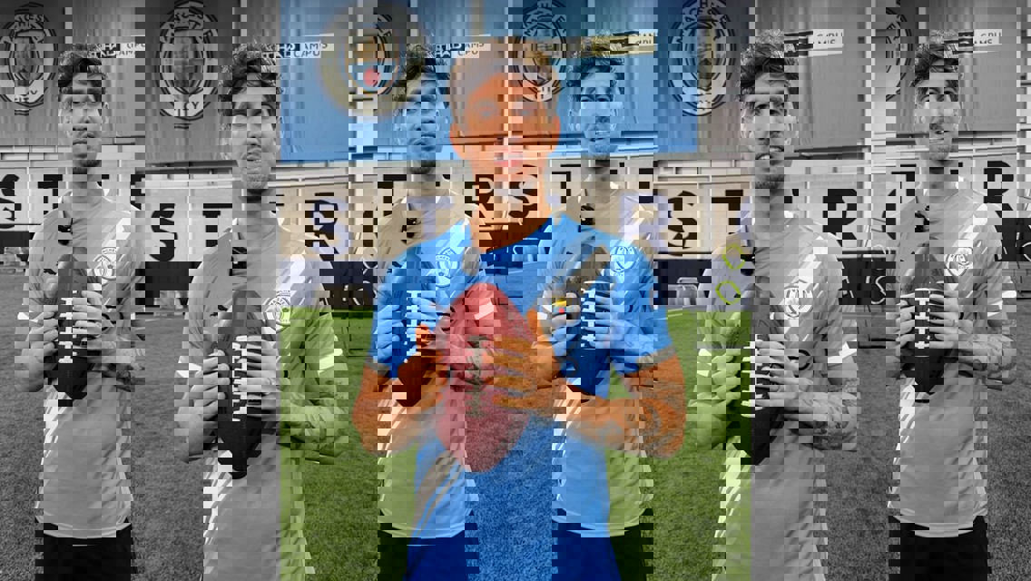 Three individuals holding American footballs wearing Manchester City jerseys in an indoor training facility with the Manchester City crest in the background.