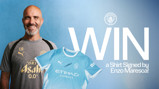 A Manchester City competition graphic featuring a person in a training kit with initials 'EM' and a shirt signed by Enzo Maresca. The text promotes winning the signed shirt.