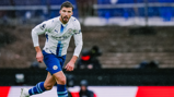 Football player in Manchester City kit running on the field during a match.