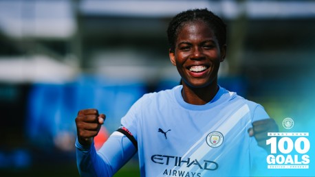 A Manchester City player in a light blue jersey celebrating a milestone with 100 goals text and Manchester City logo visible.