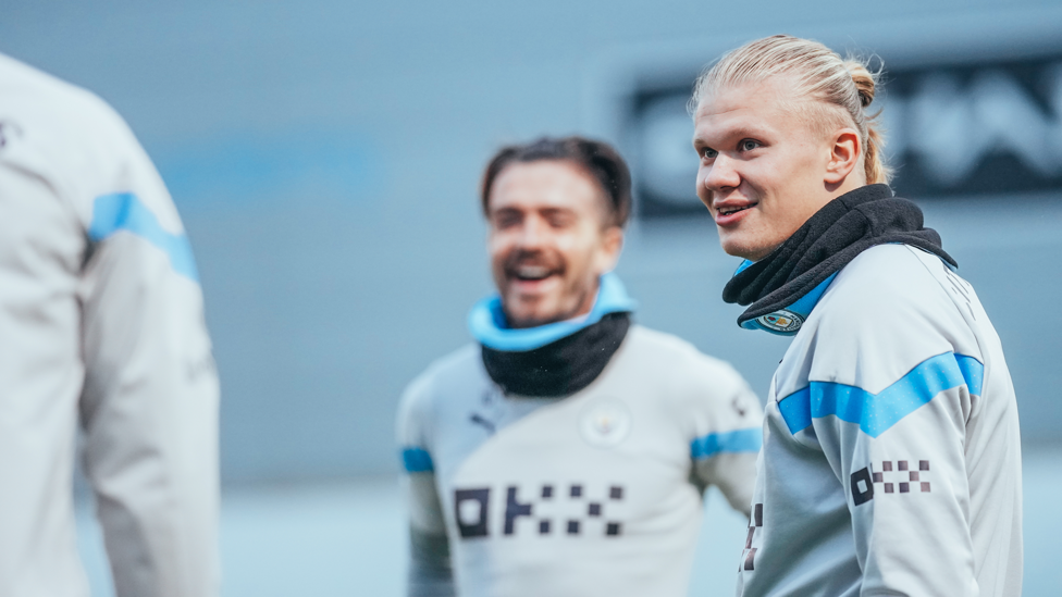 SORRIDENTES  : Haaland e Grealish de sorriso leve no treinamento. 