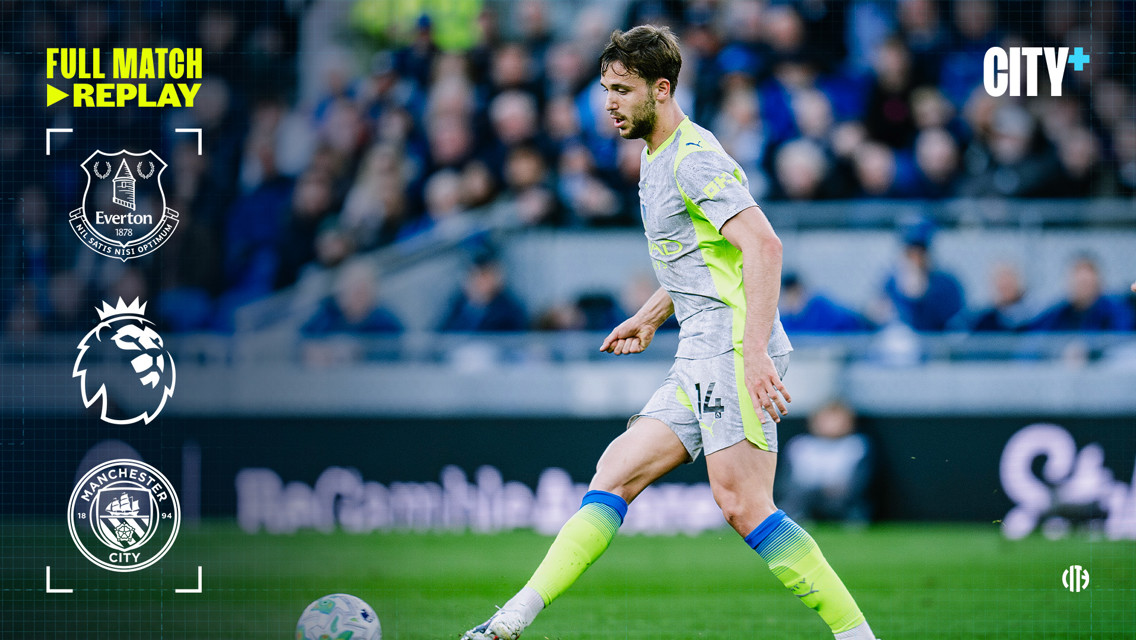 A football player wearing a gray and neon yellow uniform is on the field during a match between Manchester City and Everton in the Premier League. Logos and text related to the match replay are present.