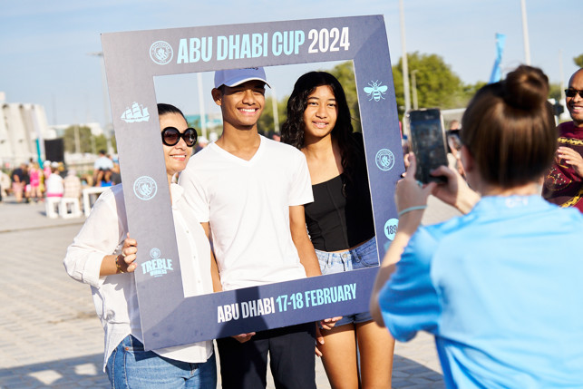 People posing with a photo frame promoting the Abu Dhabi Cup 2024 at a public event, held on February 17-18.