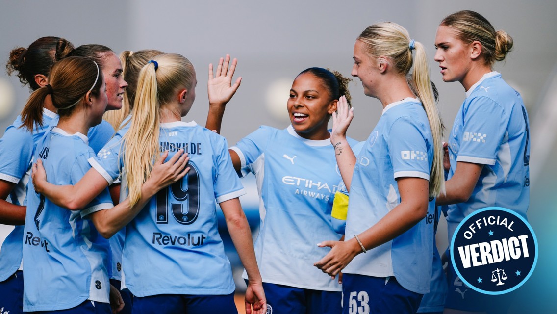 A group of Manchester City women players in light blue jerseys celebrating with high fives and smiles.