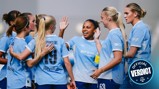 A group of Manchester City women players in light blue jerseys celebrating with high fives and smiles.