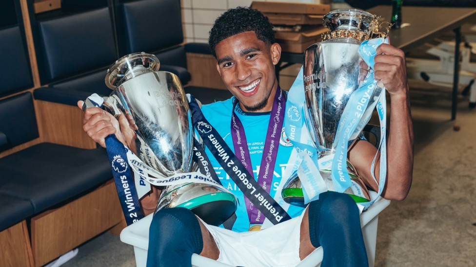 WHERE YOU BIN? : Michael Okeke poses with both PL2 trophies whilst sat in a kit bin. 