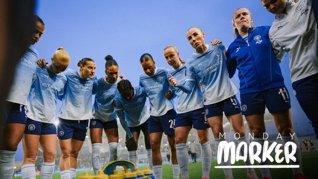 The Manchester City women's soccer team in light blue kits with 'Etihad Airways' logo are gathered in a huddle on a field with a blue sky background. The text 'Monday Marker' is overlaid.