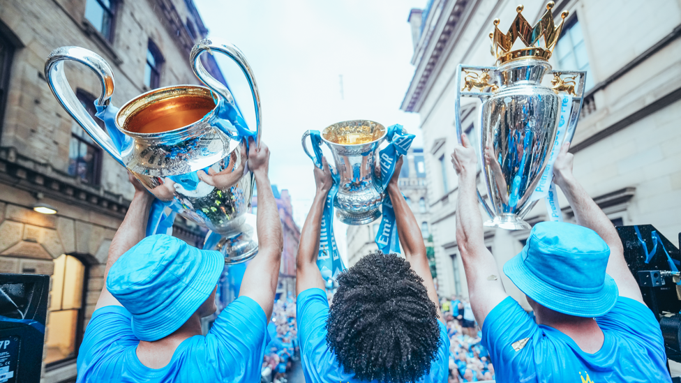 THE TREBLE  : Ketiga piala senior diangkat ke arah suporter.