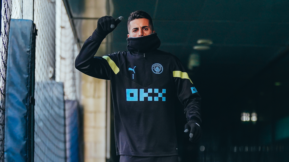 WRAPPED UP : Joao Cancelo keeping warm as the Manchester weather takes a turn