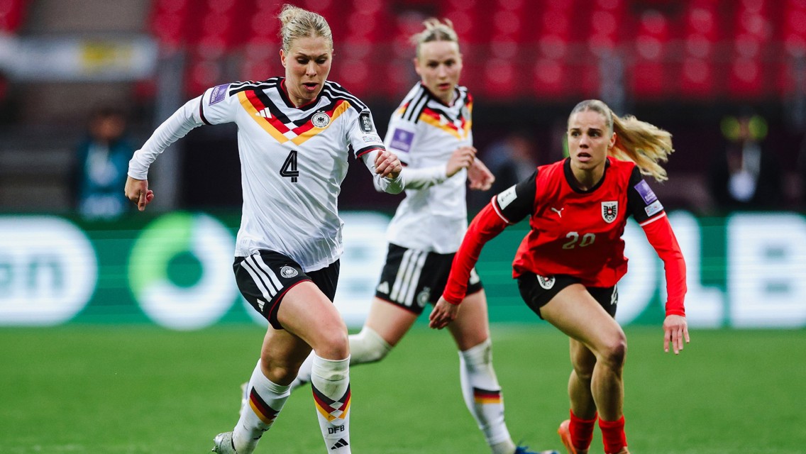 Soccer match action with German and Austrian players in mid-play. Players are wearing official national jerseys.