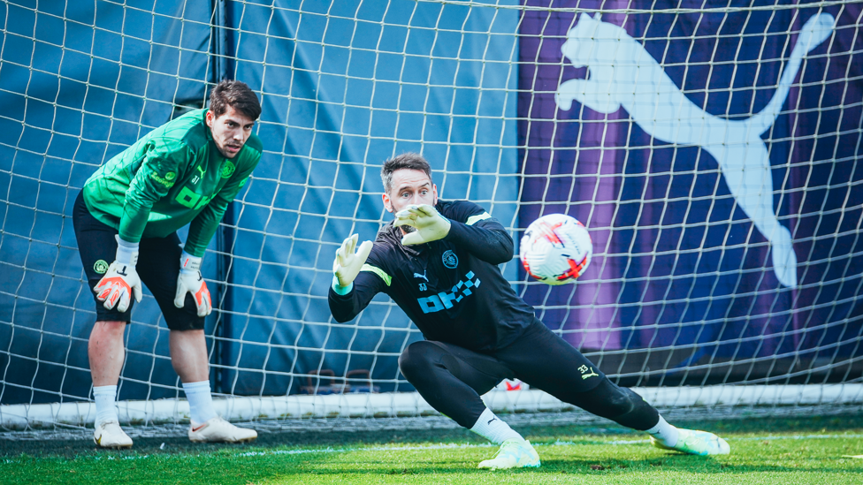 Scott Carson dives right while Stefan Ortega watches on