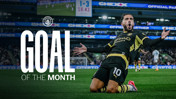 A soccer player celebrates a goal on the field. 'Goal of the Month' is prominently displayed alongside the Manchester City logo. The scoreboard in the background shows a scoreline of 1-3.