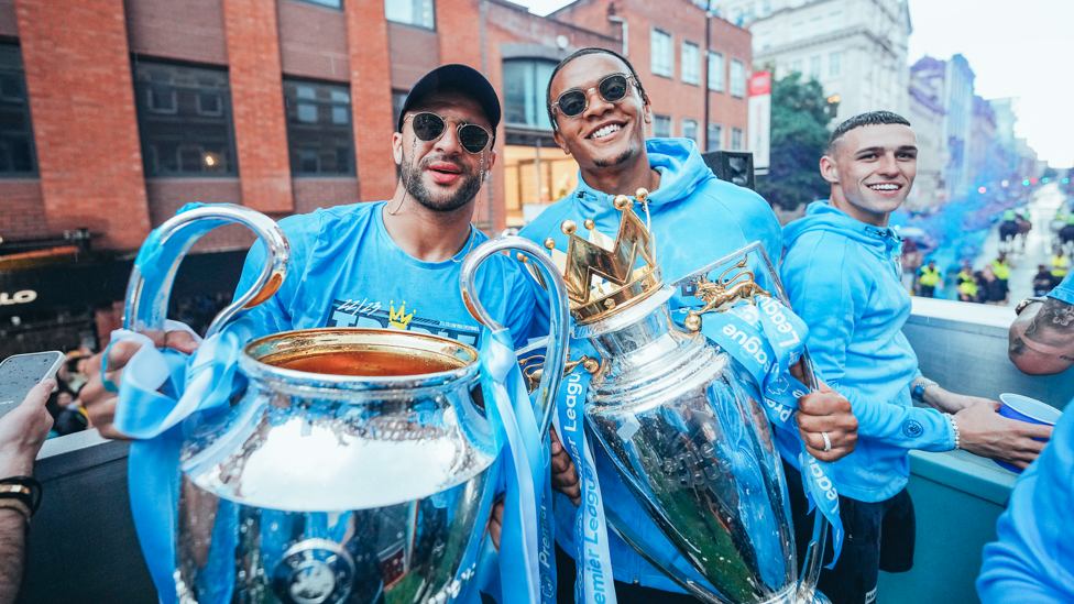 DOUBLE  : Kyle Walker dan Manuel Akanji memegang trofi Liga Champions dan Liga Inggris.