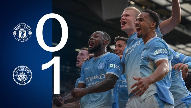 Manchester City players celebrating on the pitch after scoring against Manchester United with the score 1-0 in favor of Manchester City displayed on the left.