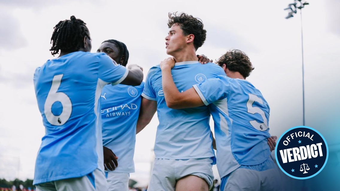 Soccer players in light blue jerseys celebrate a goal together, hugging and holding each other, with 'Official Verdict' graphic in the corner.