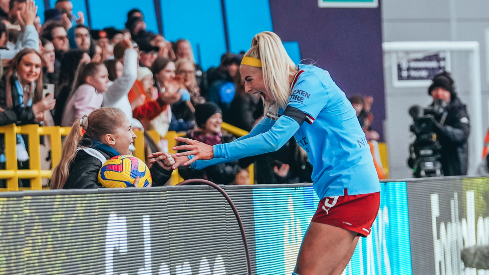 FAN FERVOUR : Chloe Kelly scores the all-important second in the 2-1 win over Arsenal - and celebrates the moment with a young fan.