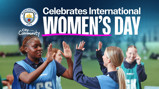 Manchester City celebrates International Women's Day with children high-fiving, featuring the Manchester City logo and community text.