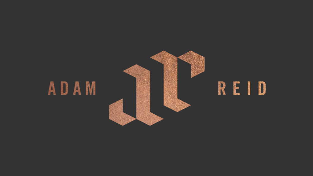 An isometric logo design featuring the letters 'A' and 'R' in a copper gradient, flanked by the words 'ADAM' and 'REID' on a dark background.