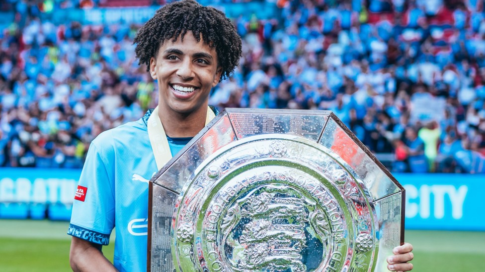RL : The young defender smiles for a picture with the 2024 Community Shield. 