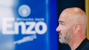 A bald man with a beard is in profile, facing a blue background with text reading 'Enzo'.