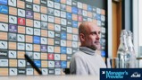A press conference setting featuring a blurred individual with a backdrop showing various sponsor logos including Puma, Etihad, and Nexen Tire.