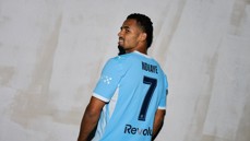 A soccer player wearing a light blue jersey with the name 'NDIAYE' and number 7 on the back looks over his shoulder.